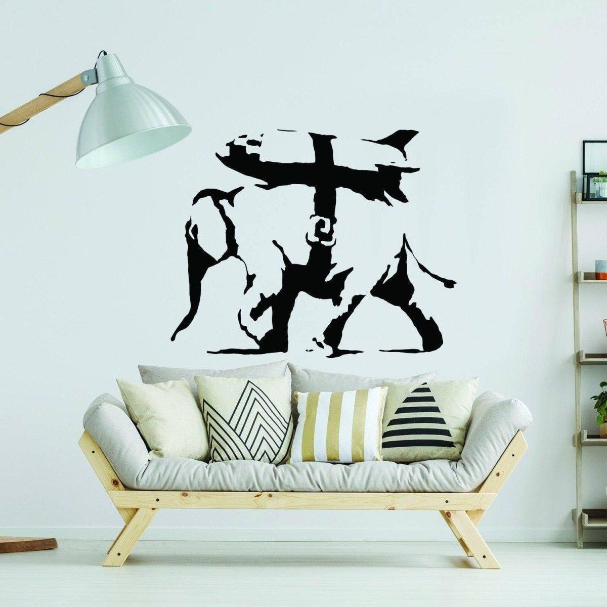 Banksy-inspired elephant graffiti vinyl sticker on living room wall above modern sofa with decorative cushions.