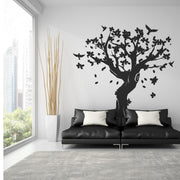 Large tree wall decal in stylish living room with black sofa, adding nature-inspired decor.