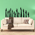 Abstract black hand silhouette vinyl decals arranged above a sofa.